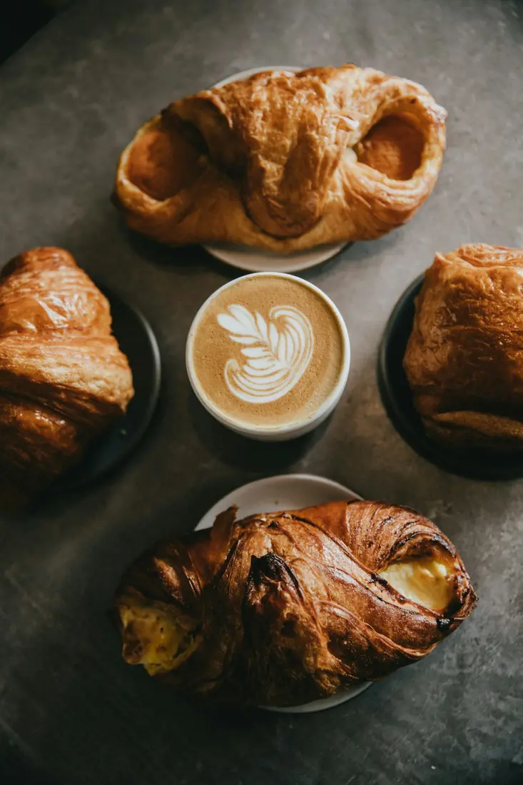 Croissants e café com leite numa mesa